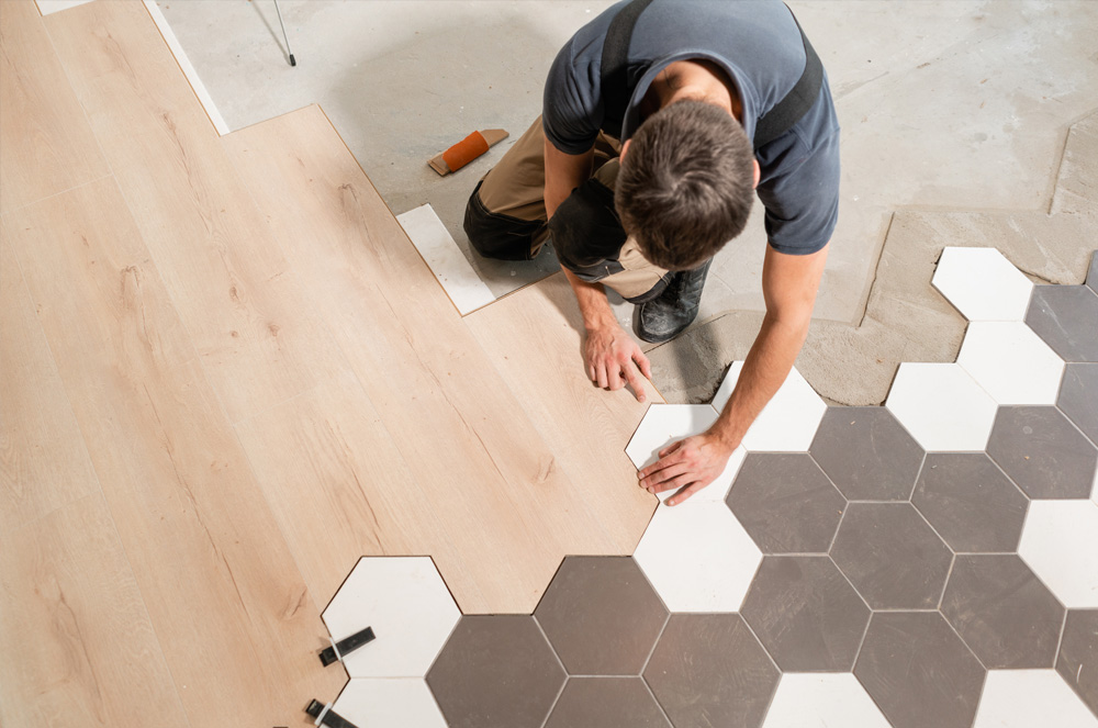 Homme qui pose du carrelage parquet